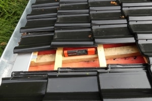 Überprüfung der Neigung am Steildach in Düsseldorf Detailaufnahme einer Baustelle am Steildach, bei der die korrekte Ausrichtung der hölzernen Lattung auf der Unterspannbahn messtechnisch geprüft wird.