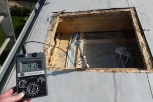 Feuchtigkeitsmessung am Flachdach mit Hydromette RTU 600 Ein Sachverständiger führt eine Messung der Materialfeuchte in einer Bauteilöffnung durch. Das Display der Gann Hydromette RTU 600 zeigt einen Wert von 41,5 M-% an.