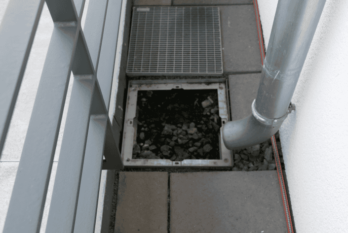 Kaskandenentwässerung auf Dachterrasse Das Bild zeigt den Auslauf einer Kaskadenentwässerung eines Hauptdaches auf die Dachterrasse eines Staffelgeschosses.